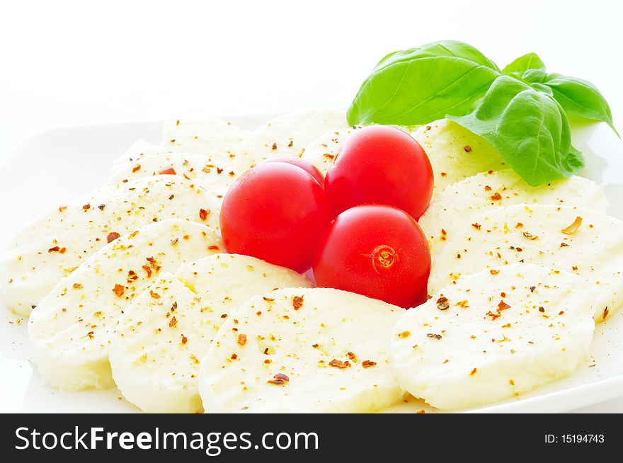 Mozzarella with tomatoes on a white background.