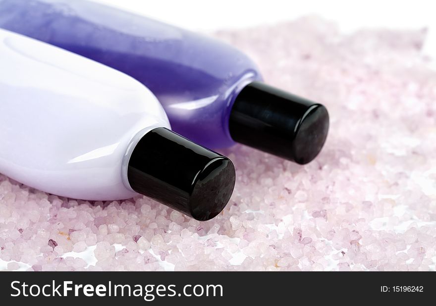 Spa and body care - herbal salt and cosmetic bottles with gel and lotion on white background