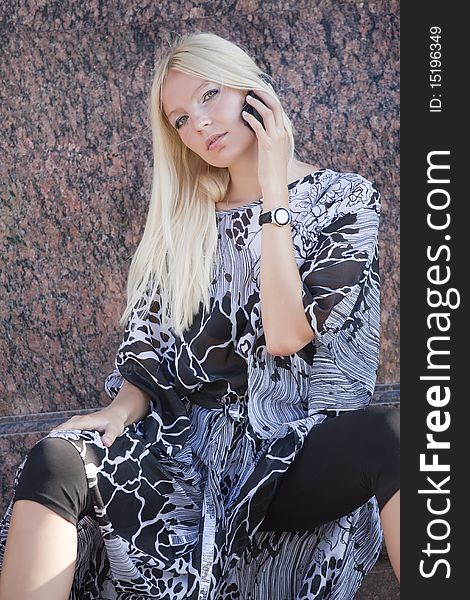 Blond fashion woman holding a cell phone. Blond fashion woman holding a cell phone