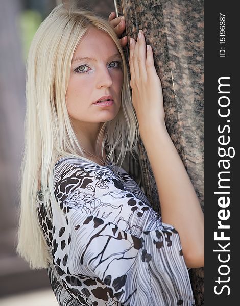 Blond fashion woman posing at the marble wall