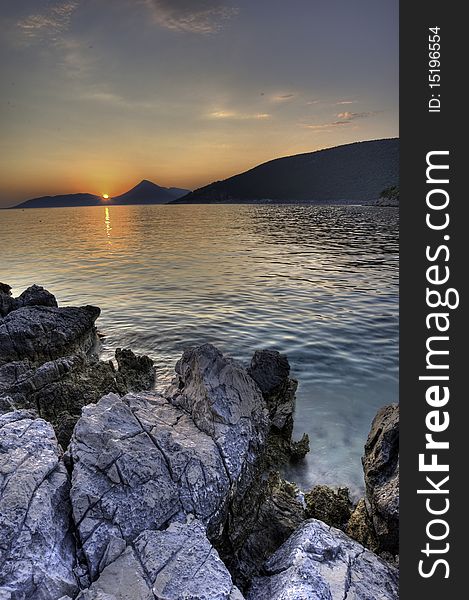 Wonderful summer sunset at the seaside of Montenegro, Adriatic sea. Mountains in the distance are the national border between Montenegro and Croatia. Wonderful summer sunset at the seaside of Montenegro, Adriatic sea. Mountains in the distance are the national border between Montenegro and Croatia