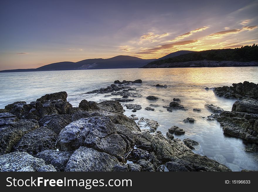 Wonderful summer sunset at the seaside of Montenegro, Adriatic sea. Mountains in the distance are the national border between Montenegro and Croatia. Wonderful summer sunset at the seaside of Montenegro, Adriatic sea. Mountains in the distance are the national border between Montenegro and Croatia