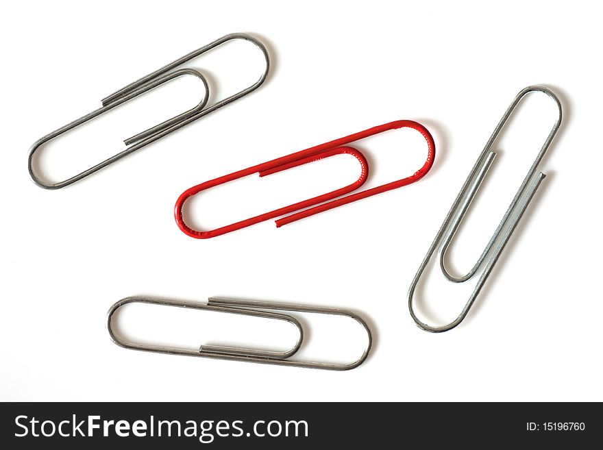 One bright red paper-clip amongst plain metal paper-clips. One bright red paper-clip amongst plain metal paper-clips