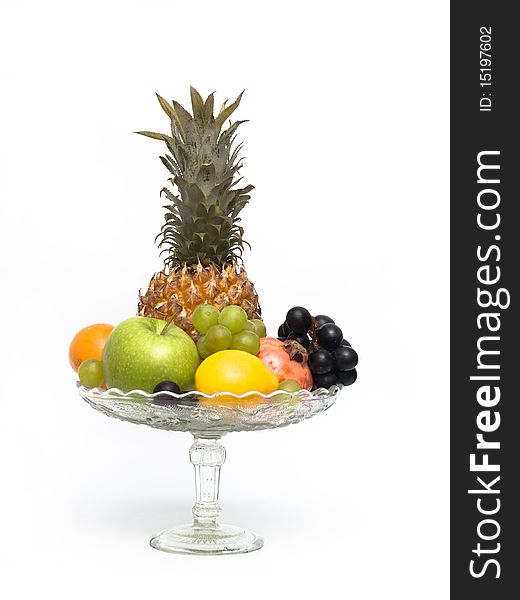 Group of different fruits in a glass vase on a white background. Group of different fruits in a glass vase on a white background