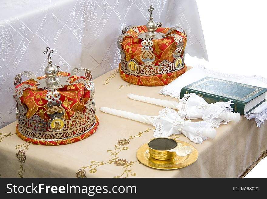 Crowns lay on a table before wedding on a cloth nearby the book of a candle and wine. Crowns lay on a table before wedding on a cloth nearby the book of a candle and wine