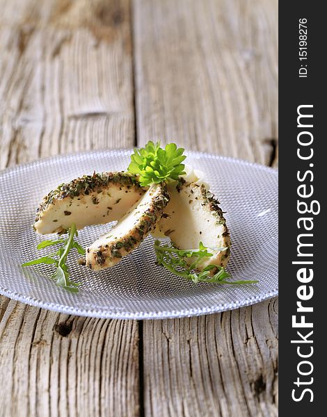 Slices of herb and spice coated cheese. Slices of herb and spice coated cheese