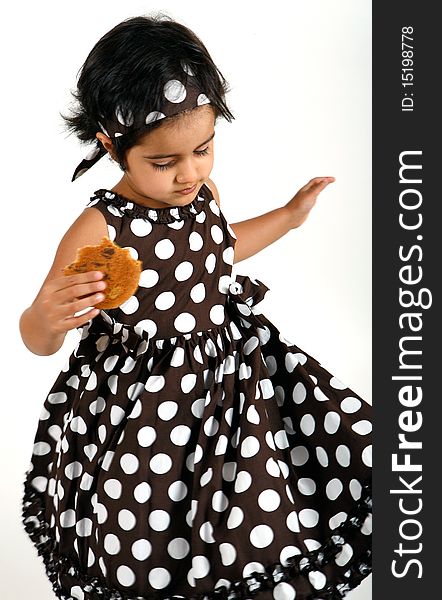 Sweet and cute toddler eating chocolate chip cookie and enjoying