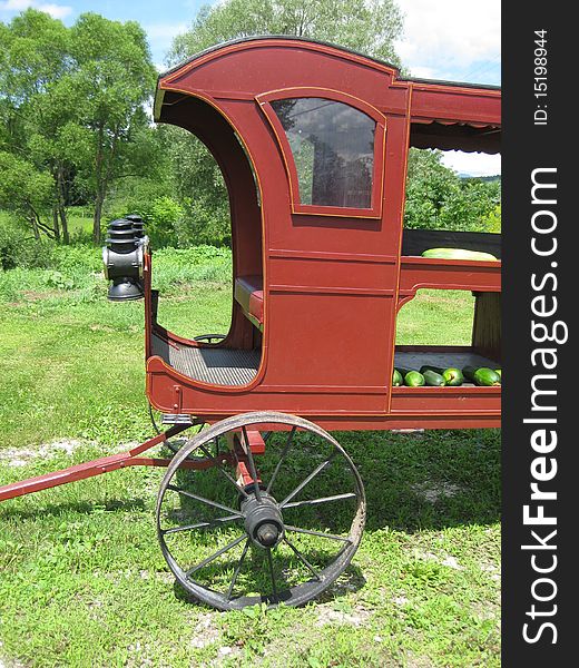 An antique vegetable wagon that a peddler would have used is still being used for vegetables as a vegetable stand.