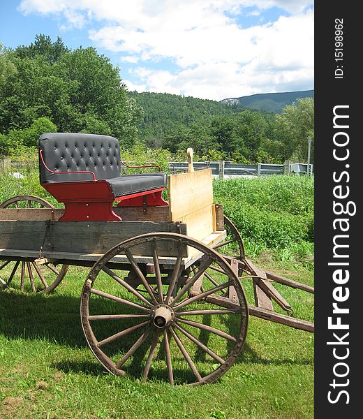 An old buckboard sits in a field as if it just got back from a ride.
