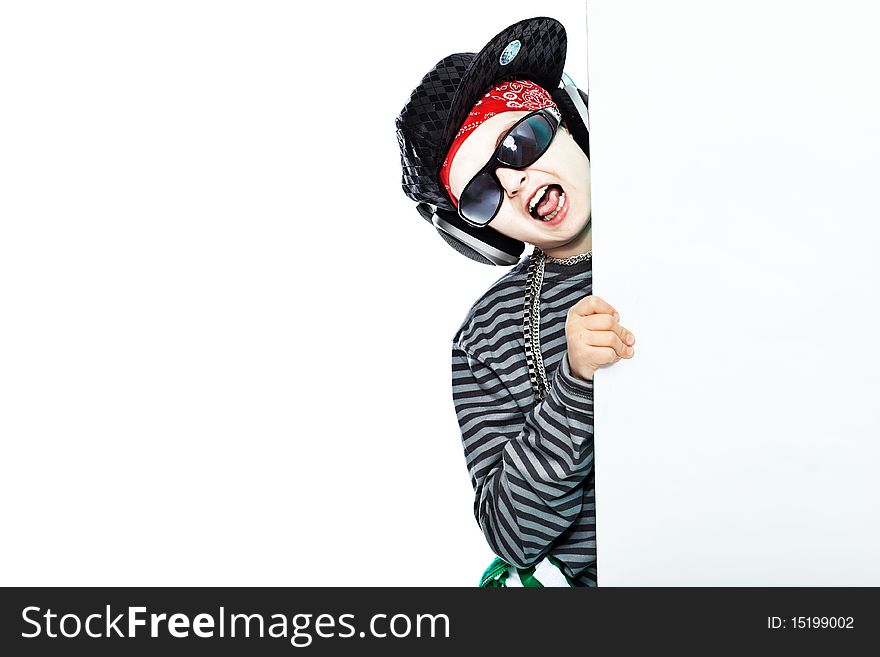 Shot of a trendy teenager listening to music in headphones and holding white board. Isolated over white background. Shot of a trendy teenager listening to music in headphones and holding white board. Isolated over white background.