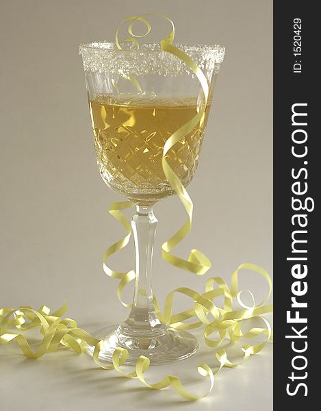 Champagne glass with yellow ribbon and white background