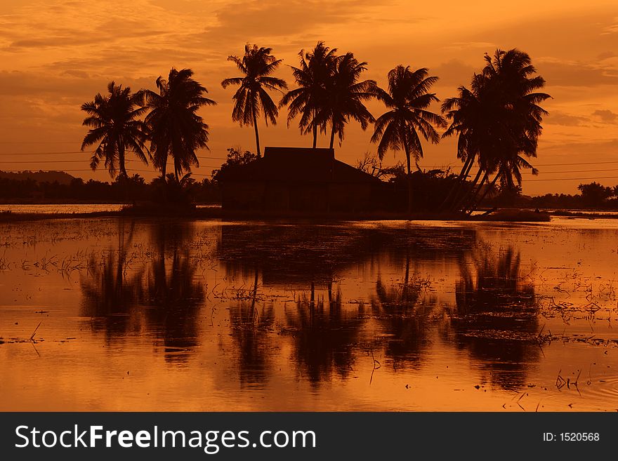 Traditional Malay village sunset view in silhouette. Traditional Malay village sunset view in silhouette.