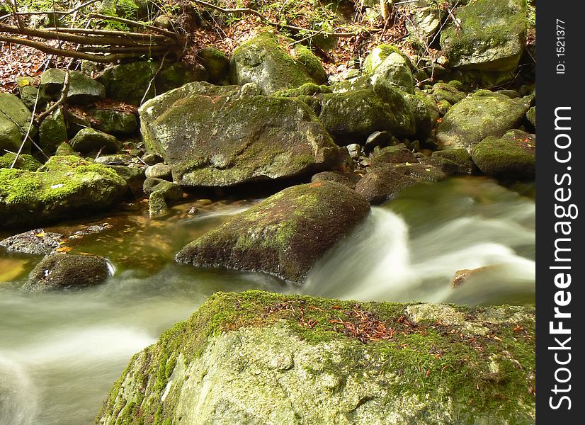 Water flows along a mountain river stream.