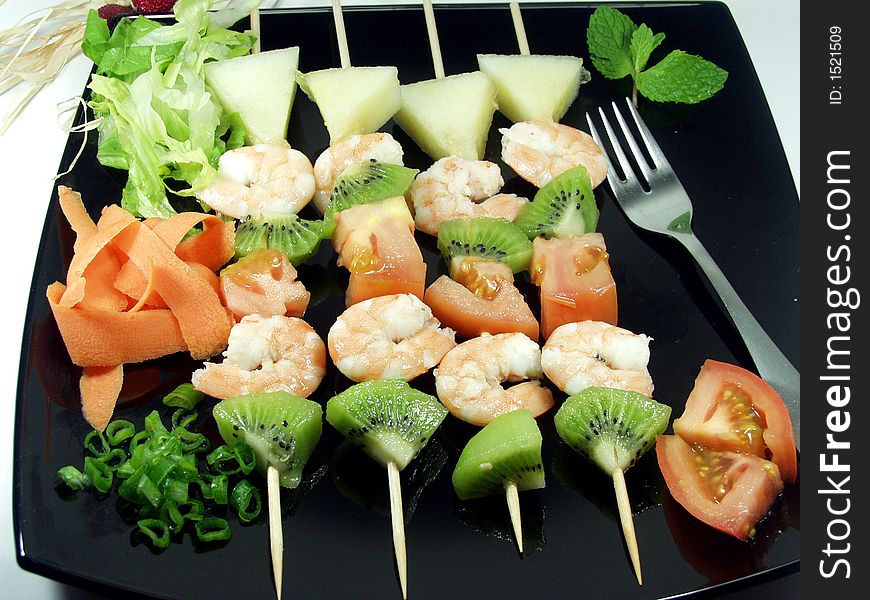 Shrimps snacks served on a black platter whit decoration