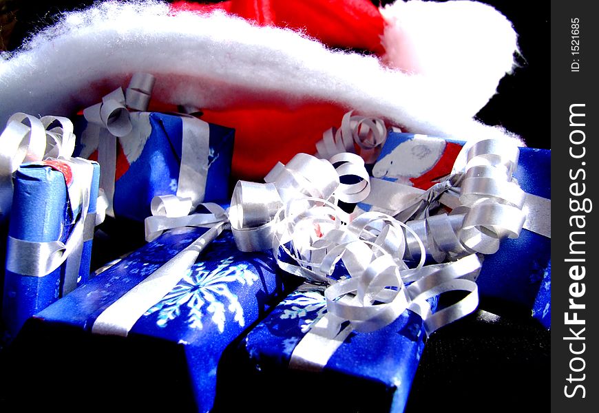 Wrapped Christmas gifts with Christmas hat on the top. Wrapped Christmas gifts with Christmas hat on the top