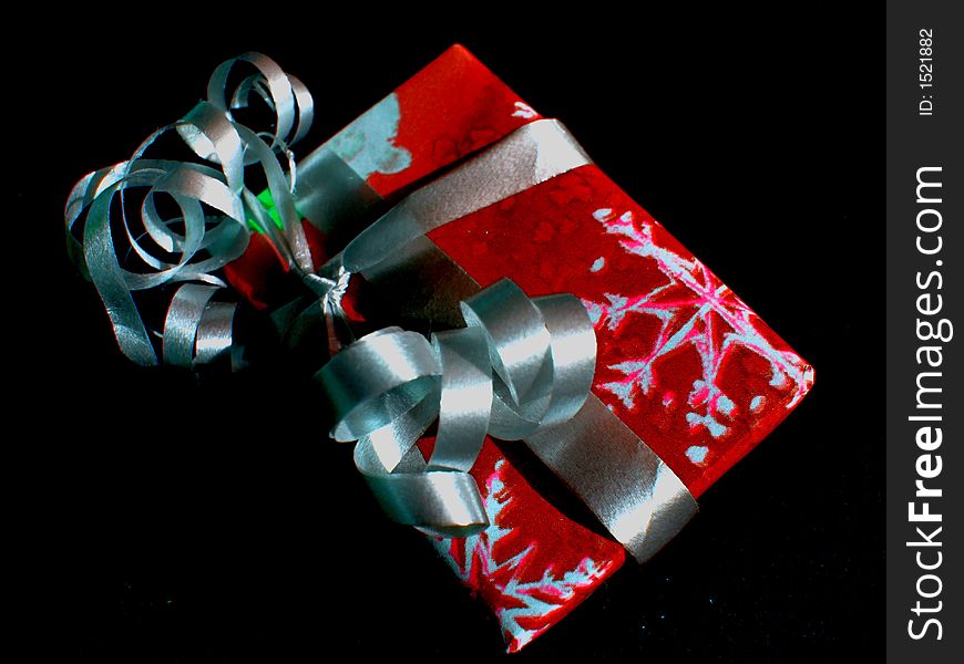 Single Christmas gift boxed and wrapped in red and white with ribbons in twirls. Single Christmas gift boxed and wrapped in red and white with ribbons in twirls