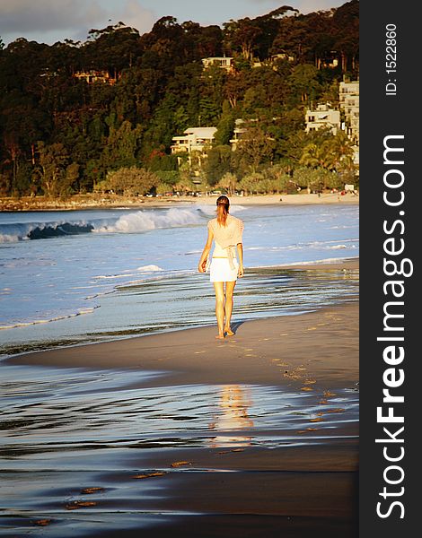 Beautiful young woman walking on the beach