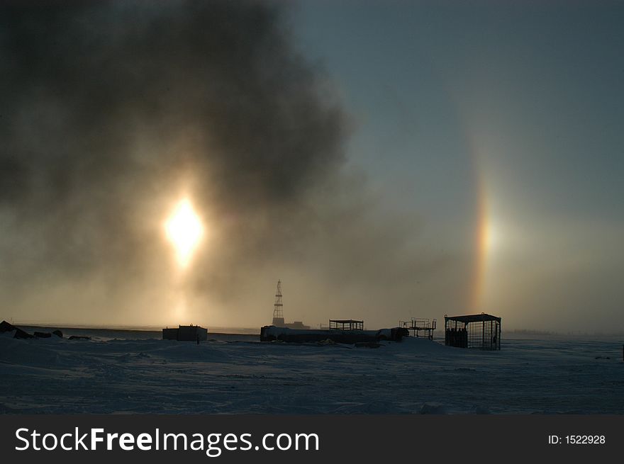 Winter. Beautiful circular rainbow and the Sun together with the smoke from the burning pit of the gas plant. Winter. Beautiful circular rainbow and the Sun together with the smoke from the burning pit of the gas plant.