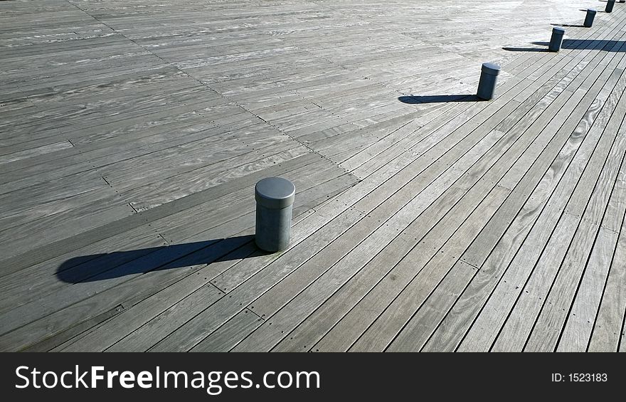 Wooden deck background with small posts and long shadows. Wooden deck background with small posts and long shadows