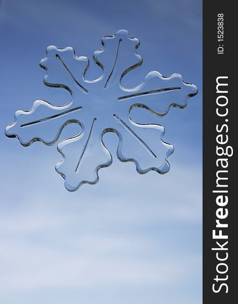 Large snowflake window decal against a soft blue sky
