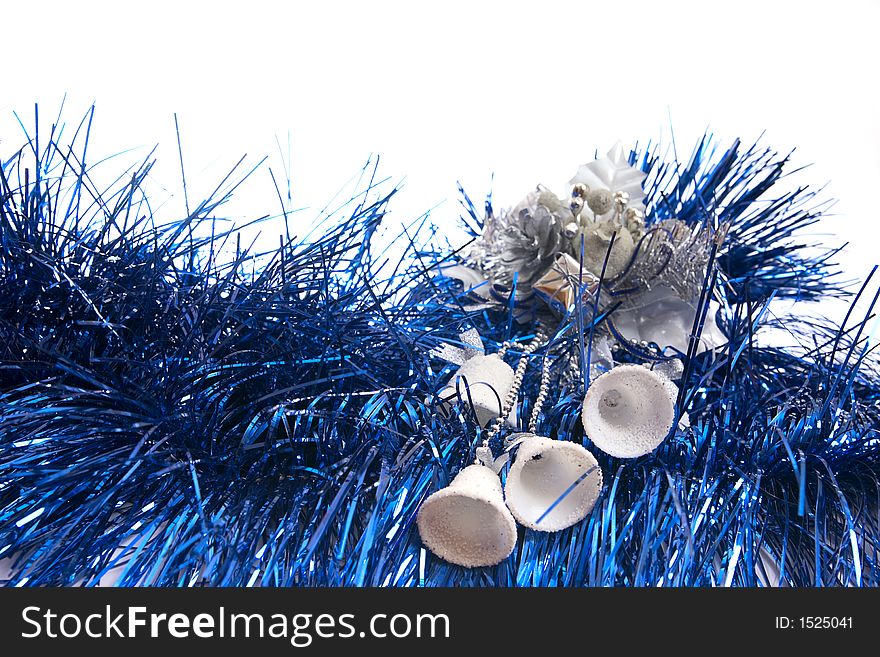 White bells lie on blue new-year tinsel on a white background