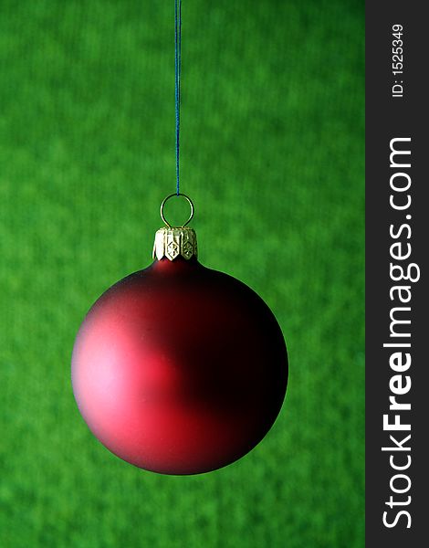 Picture of red christmas ball against green background