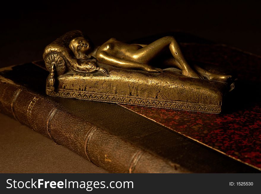 Ancient still-life with bronze odalisque on the old book.