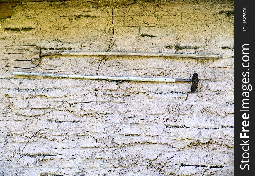 Old tools hung on a stone wall. Tools from the past and still usable. Old tools hung on a stone wall. Tools from the past and still usable.