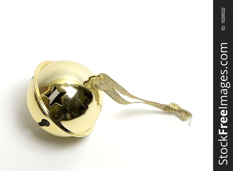 Single golden little metal bell with stars punched in it for decorating a christmas tree, with sparkling ribbon attached to it. Isolated over white. Single golden little metal bell with stars punched in it for decorating a christmas tree, with sparkling ribbon attached to it. Isolated over white