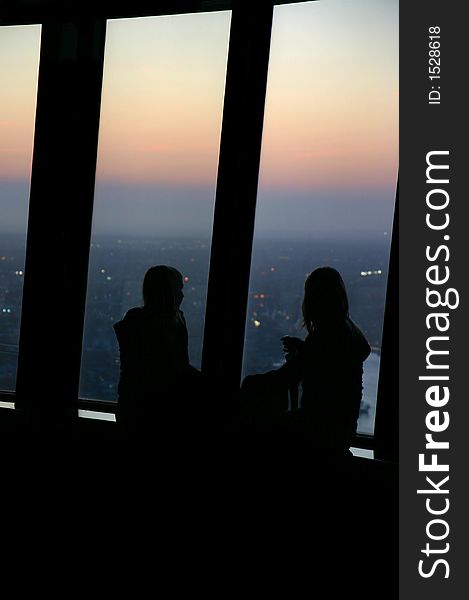 Silhouette of two girls contemplating the sunset from the Sydney tower. Silhouette of two girls contemplating the sunset from the Sydney tower.