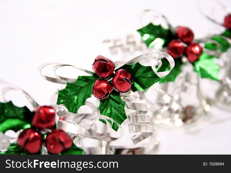 A row of shiny bells with red jingle bell berries and green holly leaves. A row of shiny bells with red jingle bell berries and green holly leaves.