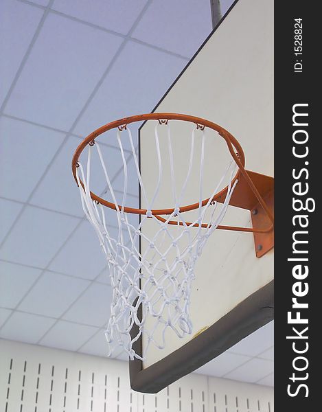 A basketball goal in a school gymnasium.