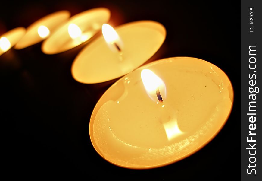 A row of candles over black background