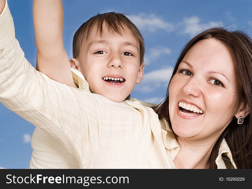 Happy woman woman with son on a background of sky. Happy woman woman with son on a background of sky
