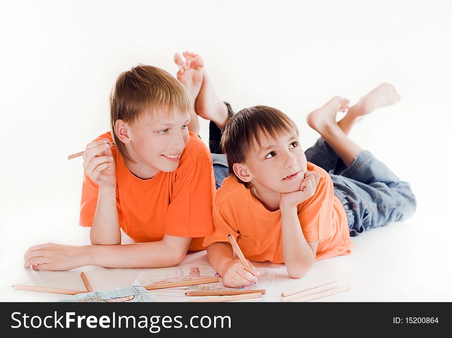 Happy brothers lying on the floor and draw. Happy brothers lying on the floor and draw