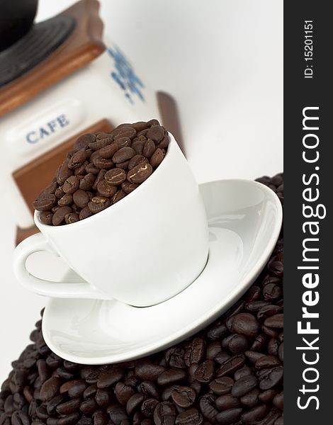 White coffee cup with beans and a coffee grinder on white background. White coffee cup with beans and a coffee grinder on white background