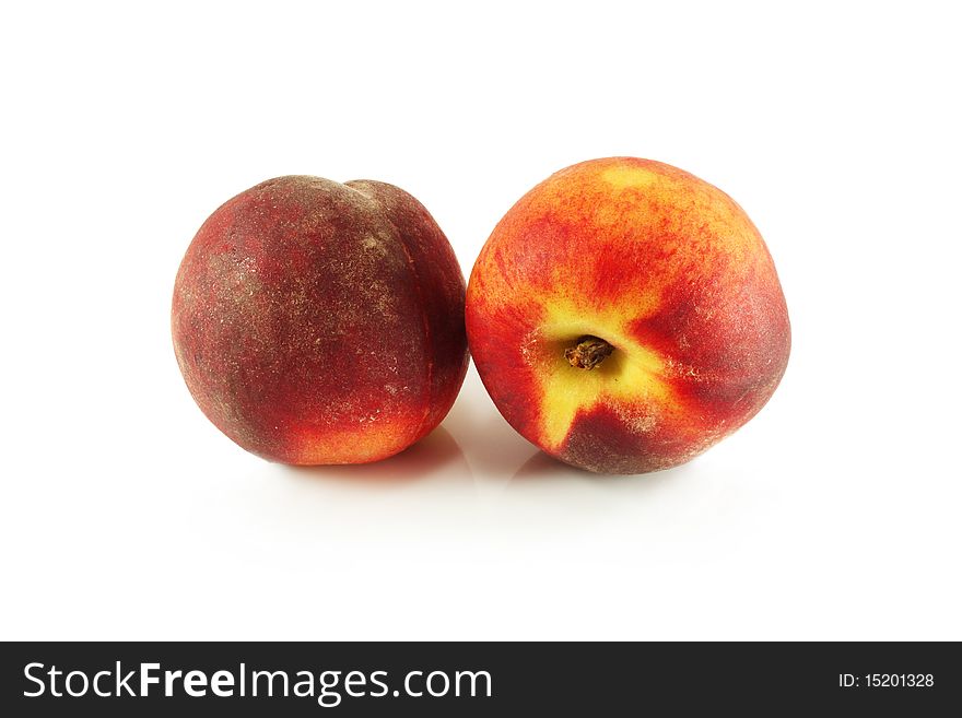 Two sweet ripe peaches on a white background