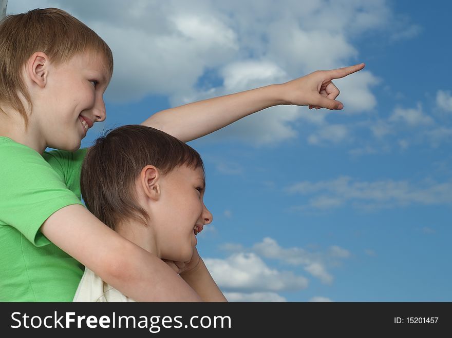 Two happy brothers stand against the sky