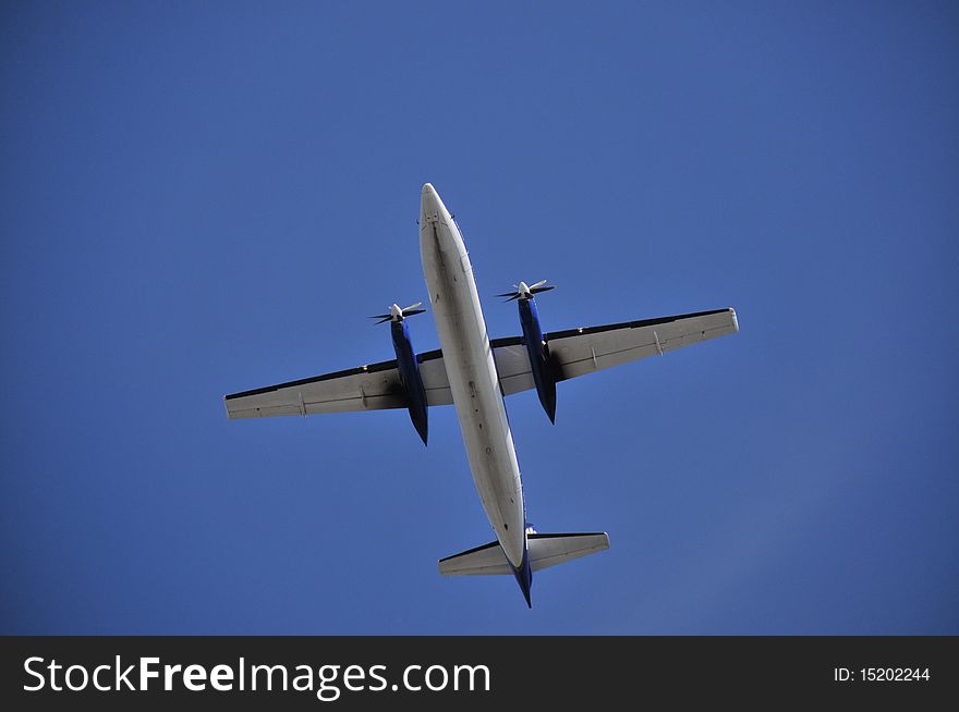 Underside of twin engined turboprop aircraft taking off.