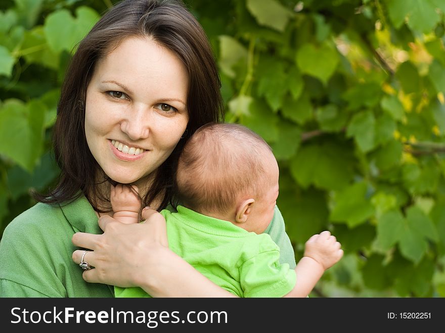 Newborn in the arms of mother nature on the background