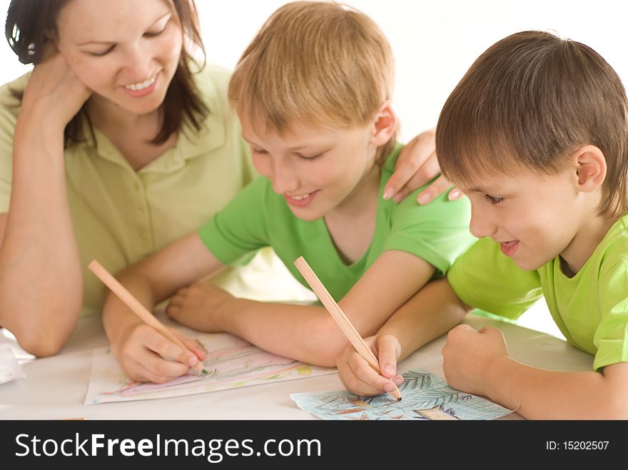 Mother at the table and draws with his sons. Mother at the table and draws with his sons