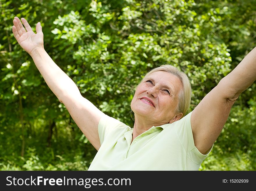 Happy elderly woman in a summer park