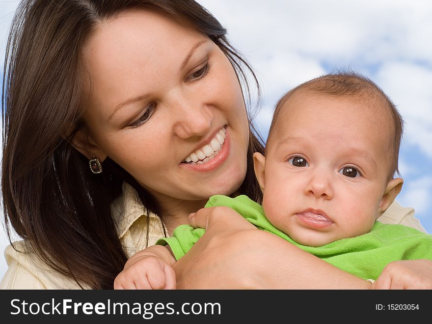 Happy mother stands and holds the baby