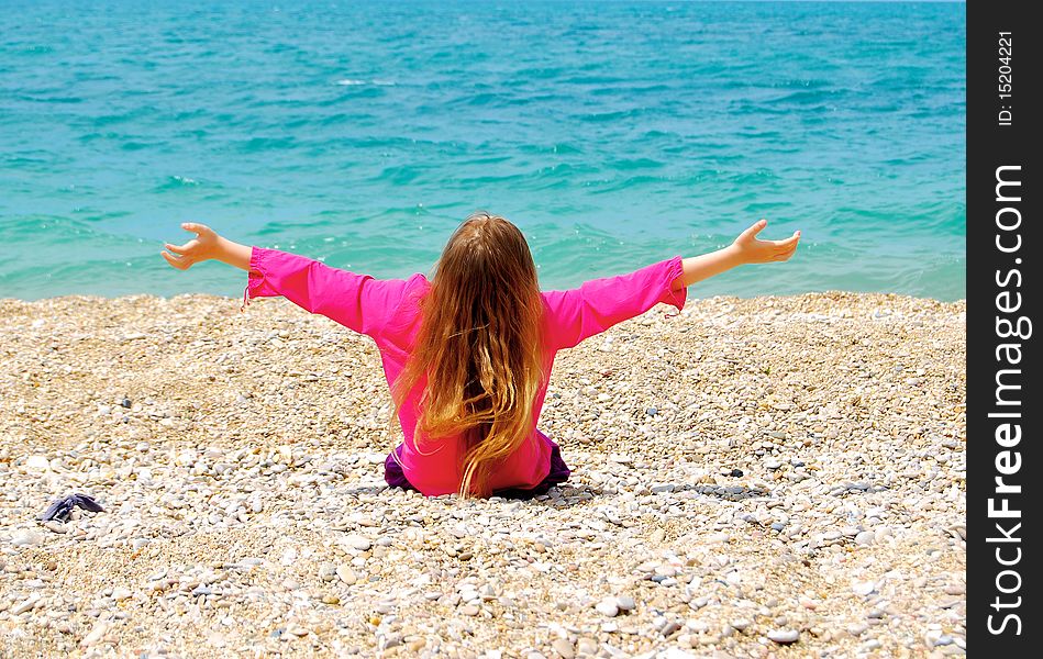 Young girl on the beach sitting and relaxing