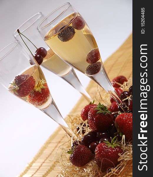 Cherry and Strawberry in three glasses of champagne. Cherry and Strawberry in three glasses of champagne.