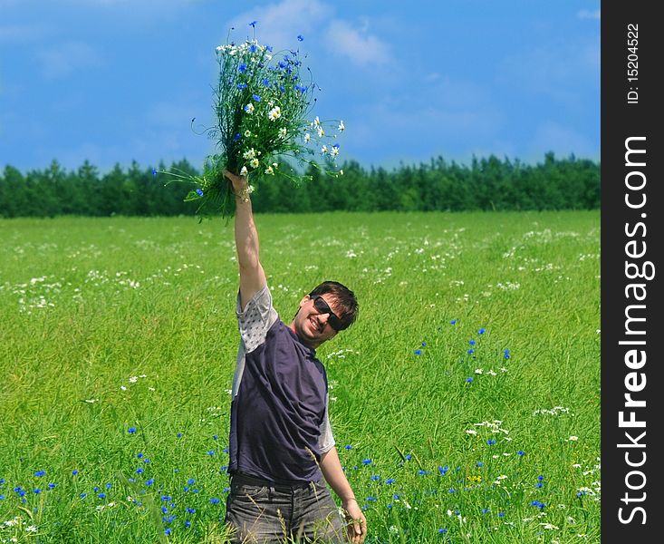 Happy young adult man with bouquet of wildflowers