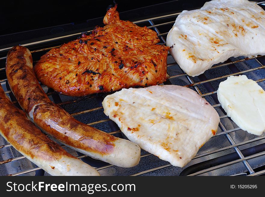 Turkey, sausages and steak on electric BBQ grill. Turkey, sausages and steak on electric BBQ grill.