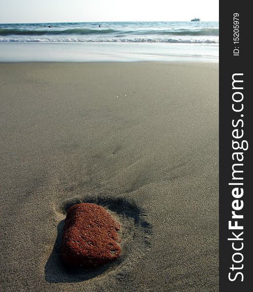 Red stone in the sand after ebb in Puerto Escondido, Mexico