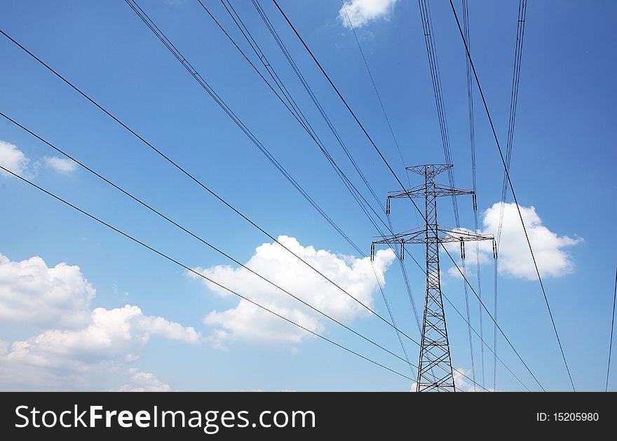 Electric pylons and wires on the cloudy sky