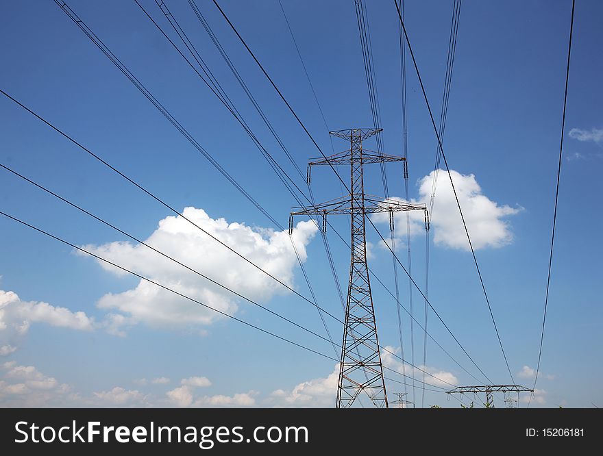 Electric pylons and wires on the cloudy sky